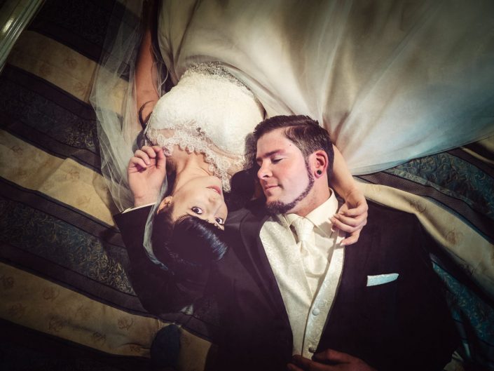 Ein Hochzeitspaar kuschelt auf einem Bett im Häckers Grand Hotel Bad Ems